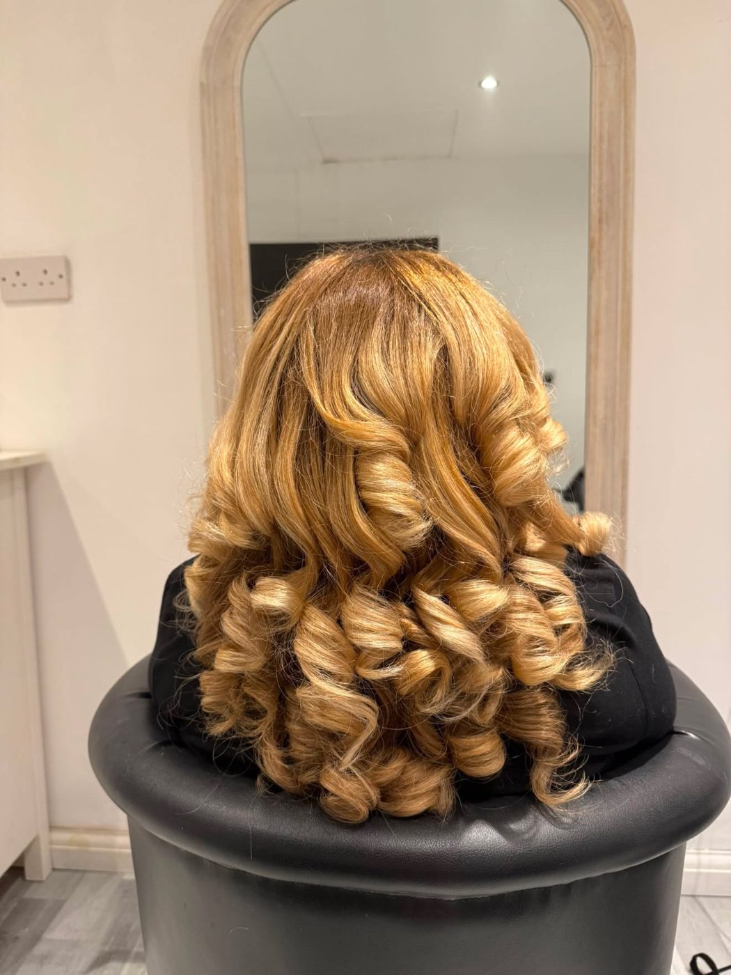 Golden blonde hair styled into voluminous bouncy pincurls